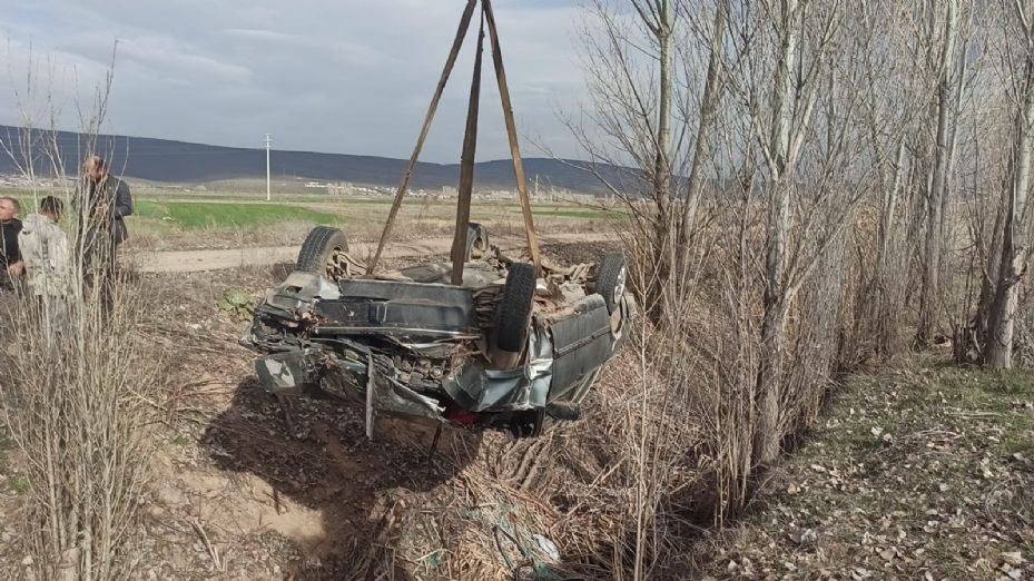 Takla atan aracın altında kalan sürücü yaralı kurtuldu