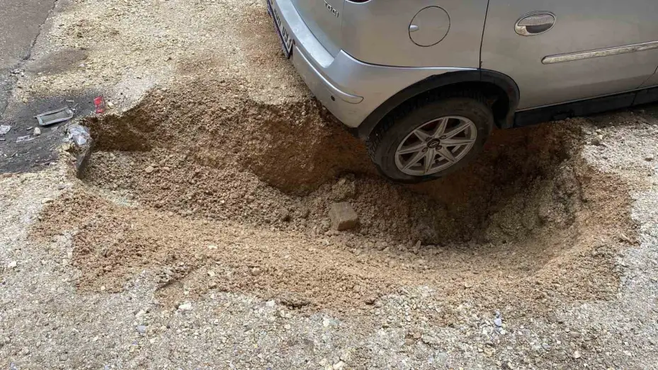 Yağışın etkisiyle çöken zeminde park halinde olan otomobil çukura düştü