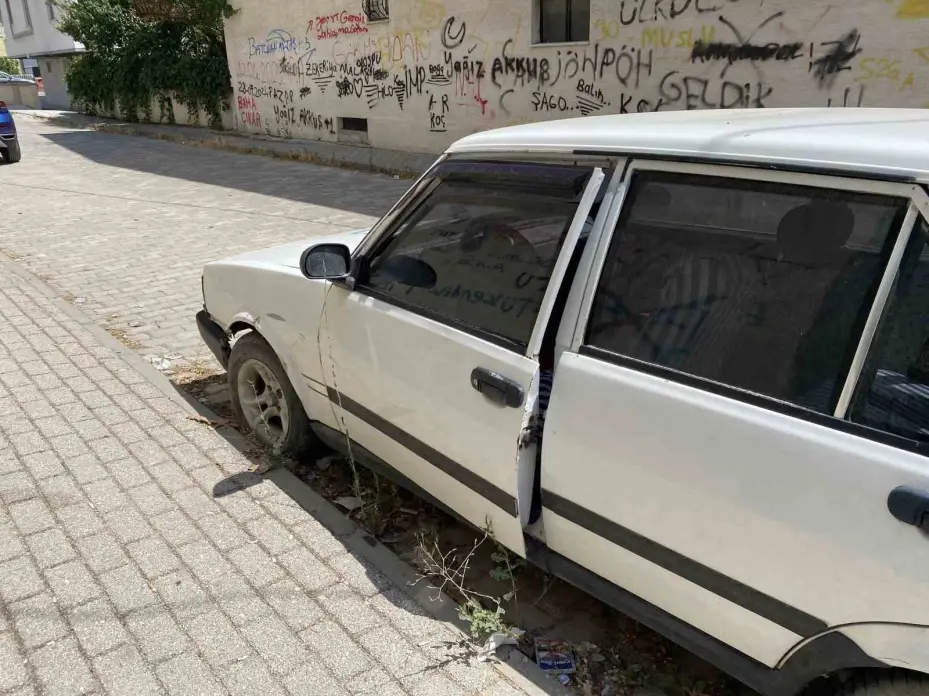 Kapısı açık ve plakasız hurda otomobil dikkat çekti