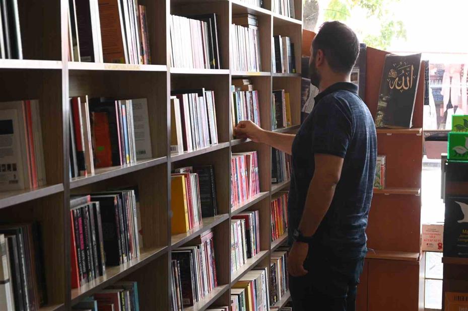 (ÖZEL) Dükkan önüne astıkları afiş vatandaşlara okuma alışkanlığı kazandırıyor