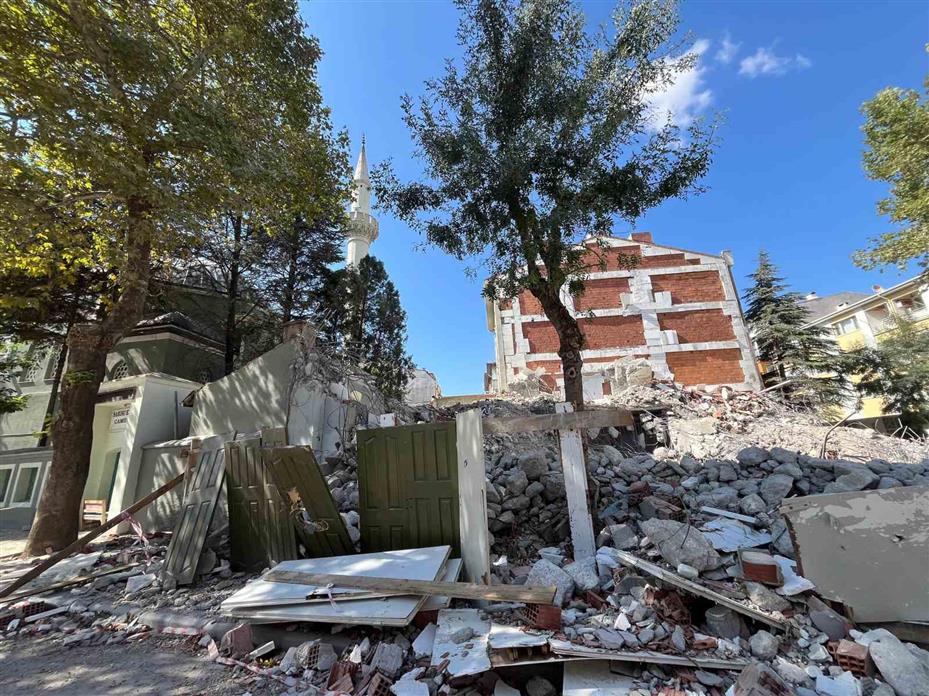 Yıkılan binanın molozları cami bahçesine döküldü