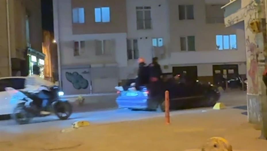 Seyir halindeki otomobillin bagajına ters oturan şahıs dikkat çekti